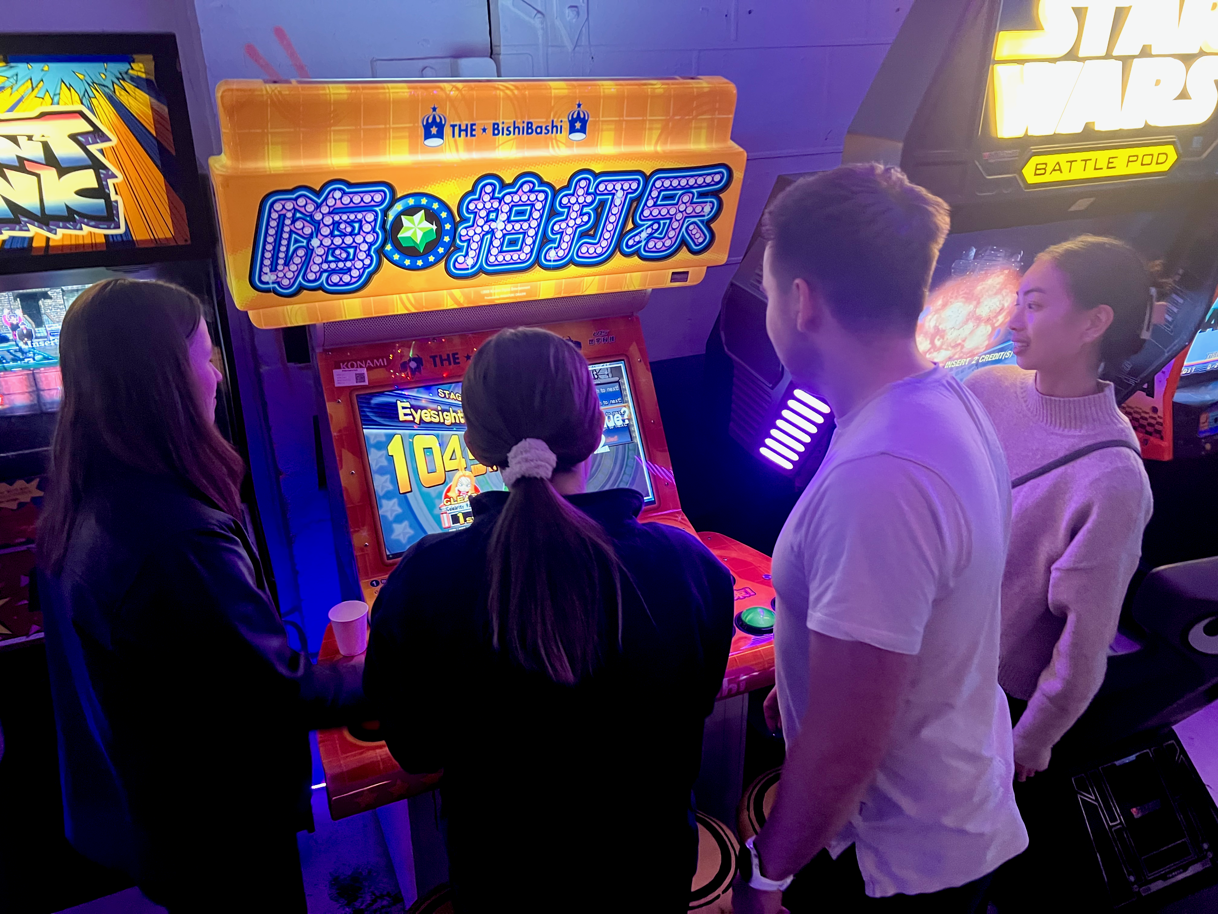 Trivia team playing an arcade challenge round at Wondercade